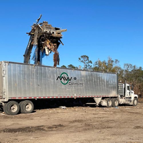 Tractor loading lumber scraps into a semi